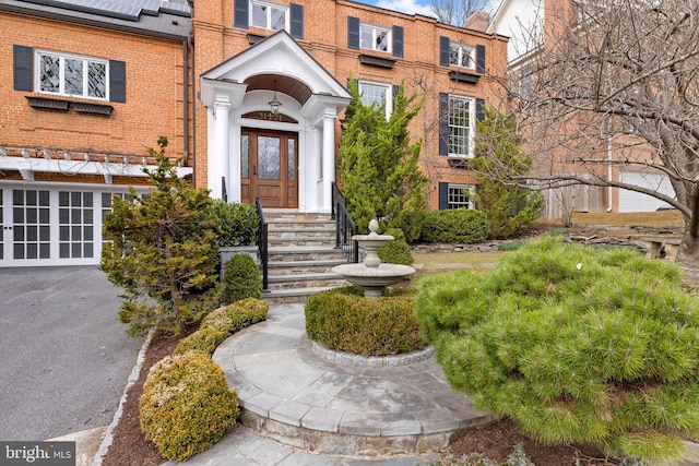 property entrance featuring brick siding, solar panels, and french doors