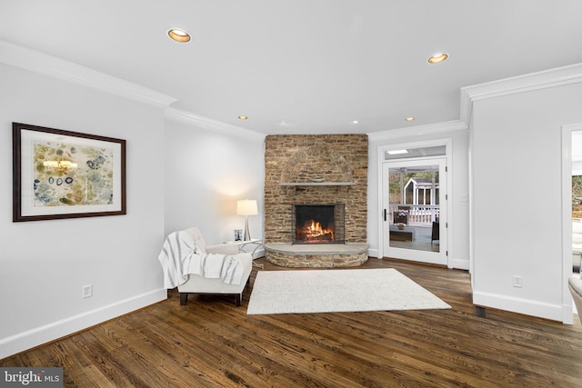 unfurnished room featuring a brick fireplace, baseboards, and wood finished floors