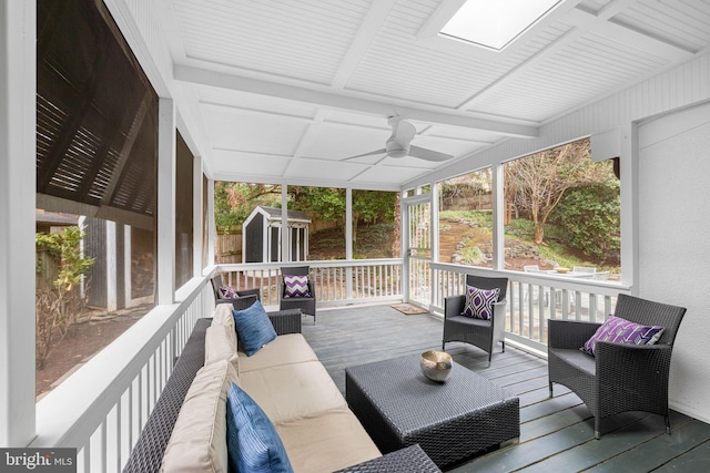 wooden terrace with outdoor lounge area, an outbuilding, a storage unit, and ceiling fan