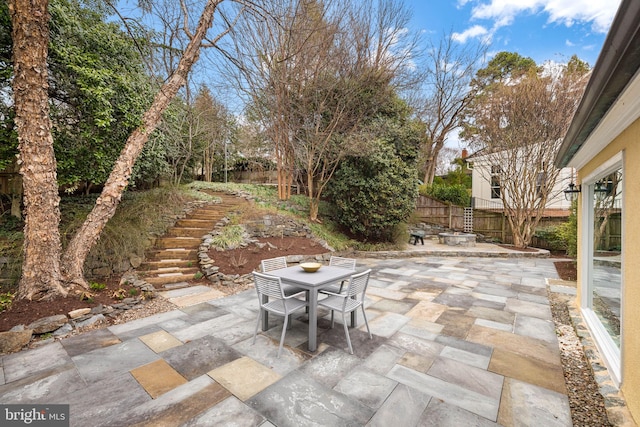 view of patio with stairway, outdoor dining area, and fence