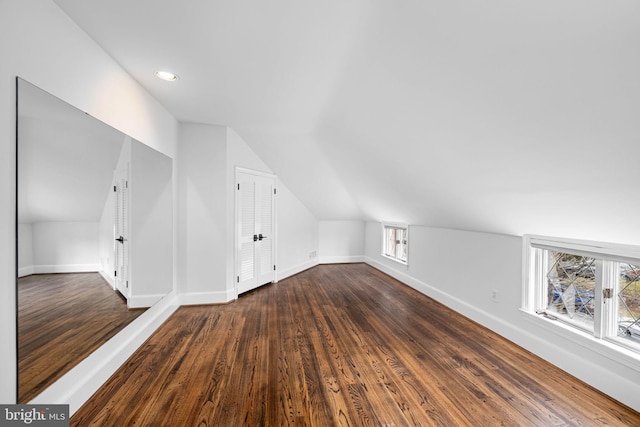 additional living space with baseboards, dark wood-style flooring, and a wealth of natural light