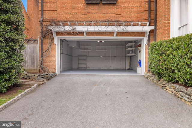 garage with driveway and fence