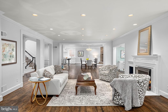 living area featuring stairway, recessed lighting, a warm lit fireplace, and wood finished floors