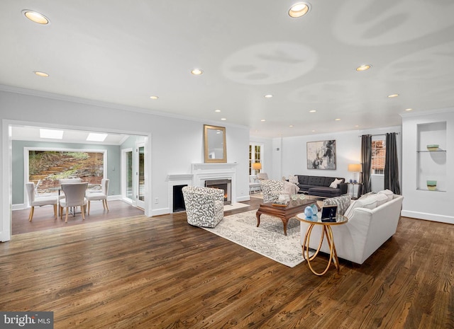 living area featuring dark wood-style floors, baseboards, a fireplace with flush hearth, recessed lighting, and ornamental molding