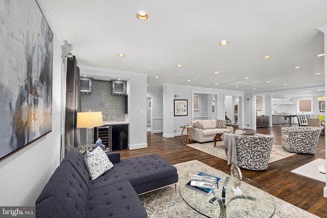 living area with wood finished floors, a dry bar, recessed lighting, and ornamental molding