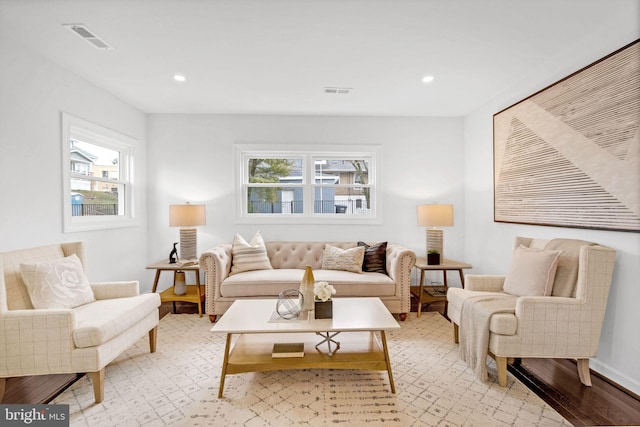 living area featuring light wood-style floors, recessed lighting, visible vents, and baseboards