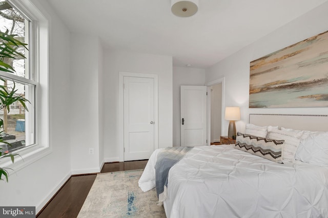 bedroom featuring baseboards and dark wood-style floors