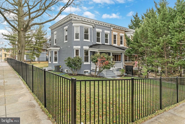 italianate-style house with a front yard, central AC unit, a porch, a fenced front yard, and brick siding