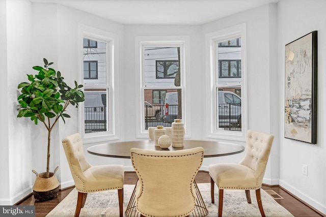 dining area with baseboards, plenty of natural light, and dark wood-style flooring