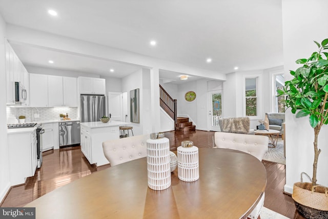 dining room with recessed lighting, stairs, and dark wood-type flooring