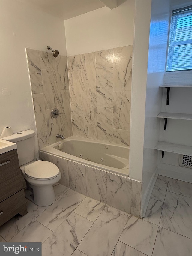 bathroom with toilet, marble finish floor, vanity, and a combined bath / shower with jetted tub