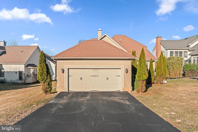 view of front facade with a garage, stucco siding, driveway, and a front lawn