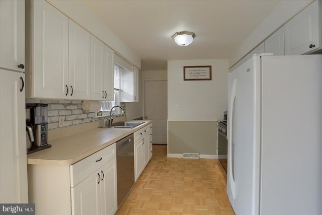 kitchen featuring visible vents, dishwasher, freestanding refrigerator, white cabinetry, and a sink