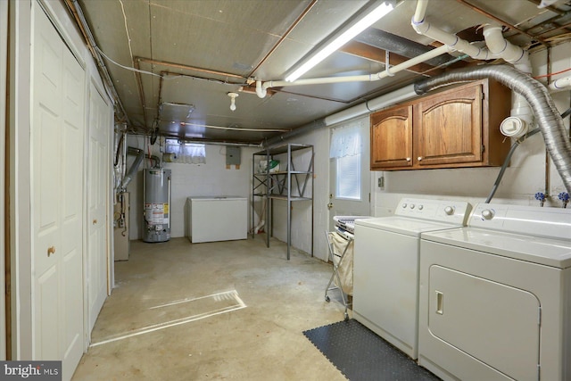 below grade area featuring gas water heater, refrigerator, and washer and clothes dryer