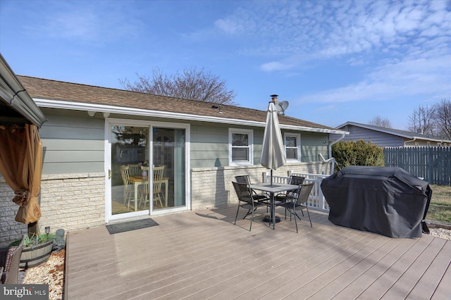 deck with outdoor dining area, fence, and grilling area