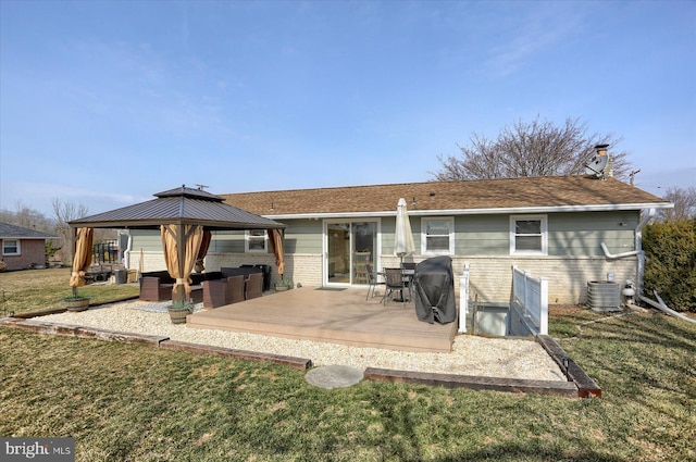 back of house featuring brick siding, a gazebo, a chimney, a deck, and a yard