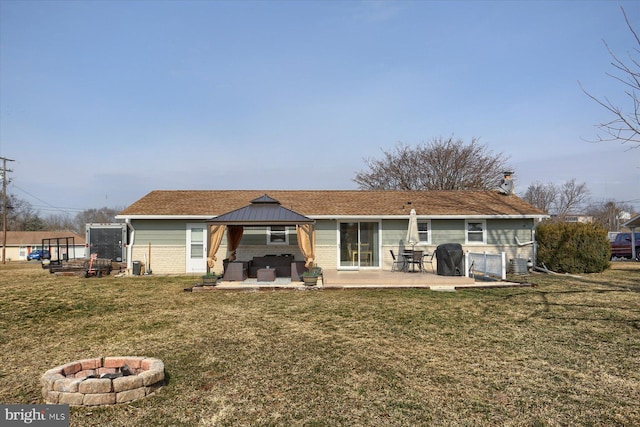 rear view of house with a gazebo, central air condition unit, a yard, and a fire pit