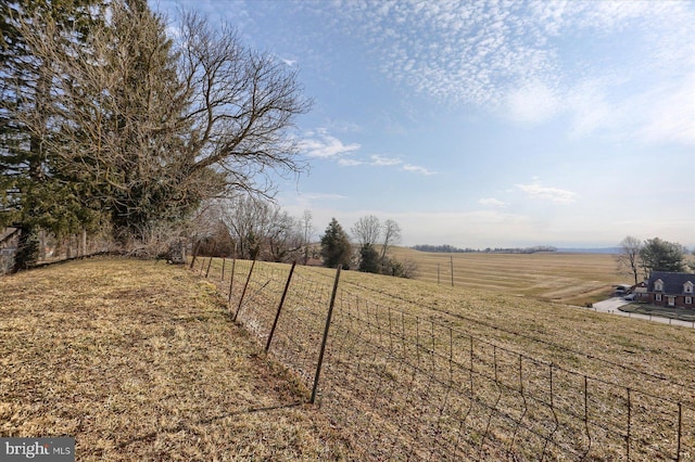 view of yard with a rural view and fence