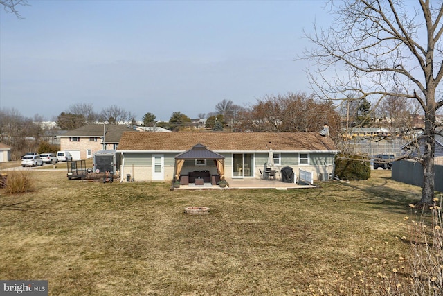 back of house featuring a yard, a patio, a fireplace, and fence