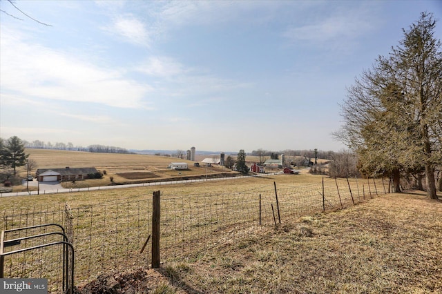 view of yard with a rural view and fence