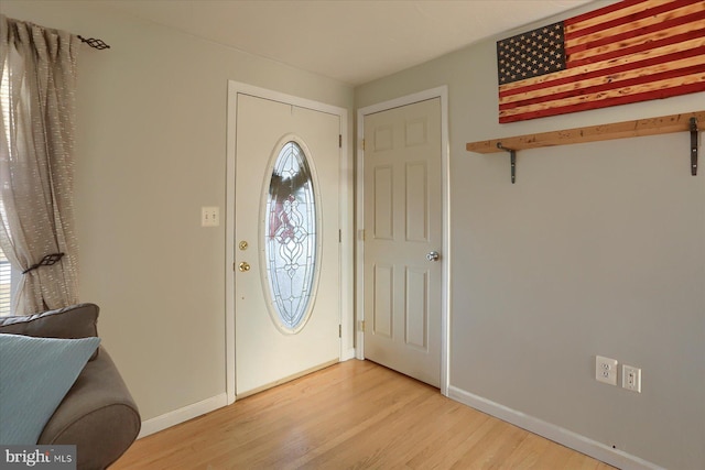 entryway with baseboards and light wood finished floors