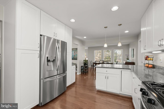 kitchen featuring recessed lighting, appliances with stainless steel finishes, a peninsula, wood finished floors, and white cabinetry