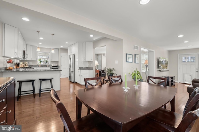 dining space with recessed lighting, visible vents, and wood finished floors