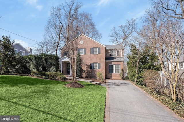 traditional-style house featuring brick siding and a front lawn