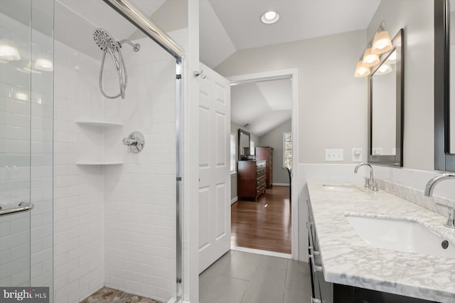 bathroom featuring lofted ceiling, a shower stall, and a sink