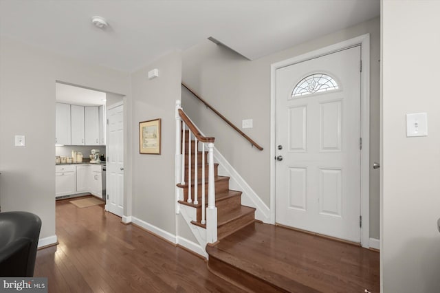 foyer entrance featuring stairway, baseboards, and dark wood-style floors