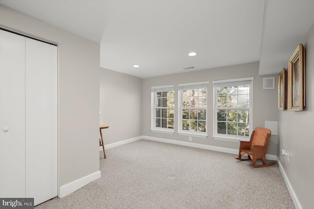 sitting room with a wealth of natural light, visible vents, carpet, and baseboards