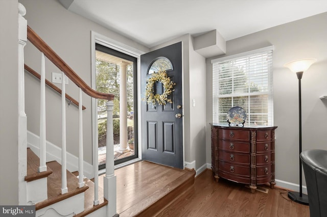 foyer featuring stairway, wood finished floors, and baseboards