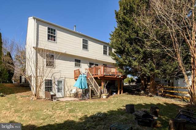 back of house with a lawn, a deck, fence, an outdoor fire pit, and stairs