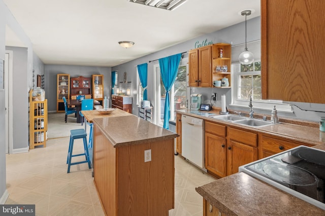 kitchen with range with electric cooktop, a kitchen island, light floors, white dishwasher, and a sink