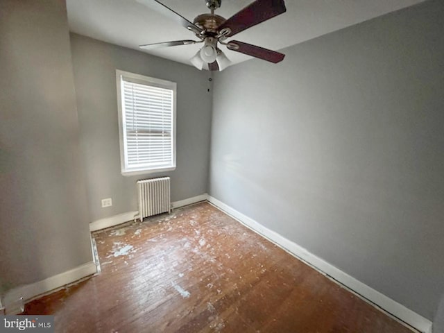 unfurnished room featuring radiator, a ceiling fan, and baseboards