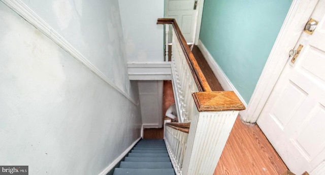 stairs featuring baseboards and wood finished floors