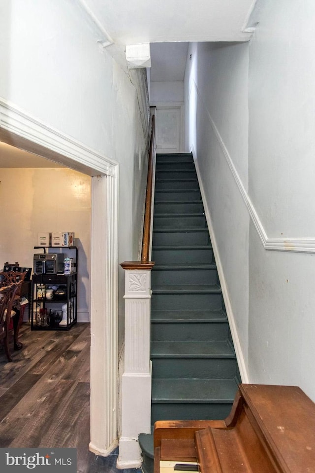 stairs featuring wood finished floors