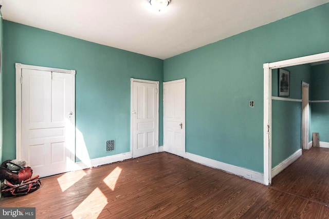 unfurnished bedroom with wood finished floors and baseboards