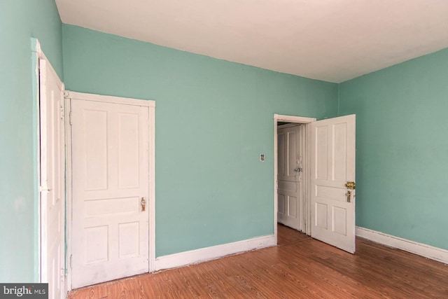 unfurnished bedroom featuring baseboards and wood finished floors