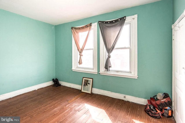 empty room featuring wood finished floors and baseboards