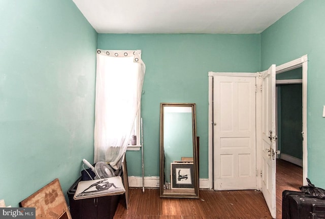 interior space with baseboards and wood finished floors