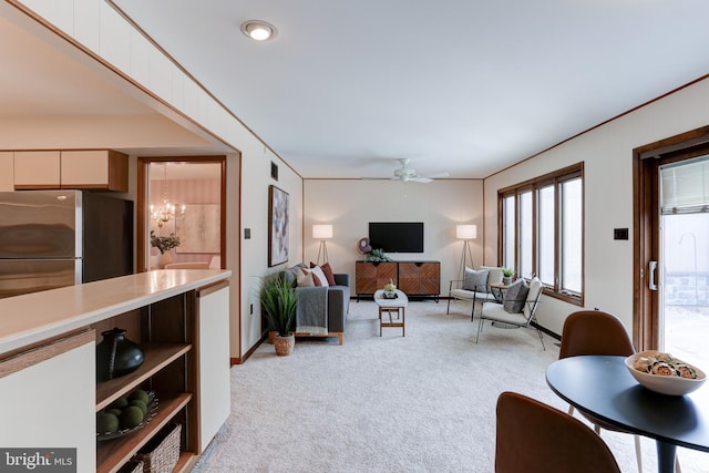 living area with baseboards, visible vents, light carpet, crown molding, and ceiling fan with notable chandelier