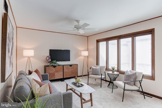 living room featuring visible vents, baseboards, ornamental molding, carpet flooring, and a ceiling fan