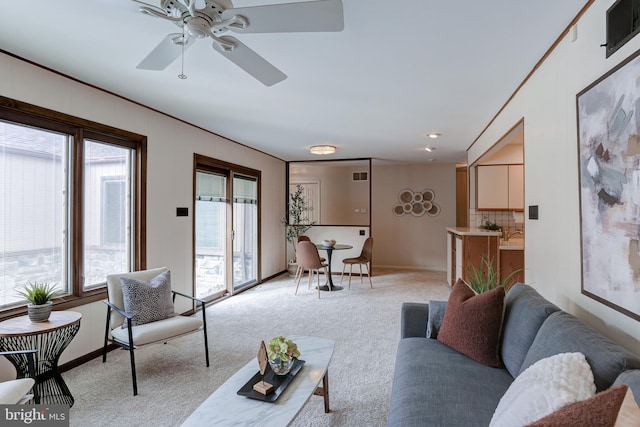 living room with visible vents, baseboards, and light carpet