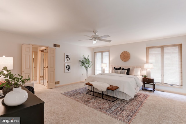 bedroom with a ceiling fan, light colored carpet, and visible vents