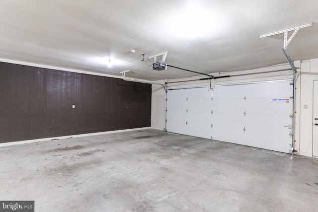 garage featuring a garage door opener and wood walls