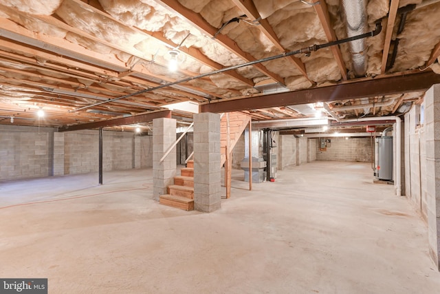 unfinished below grade area featuring stairway and water heater