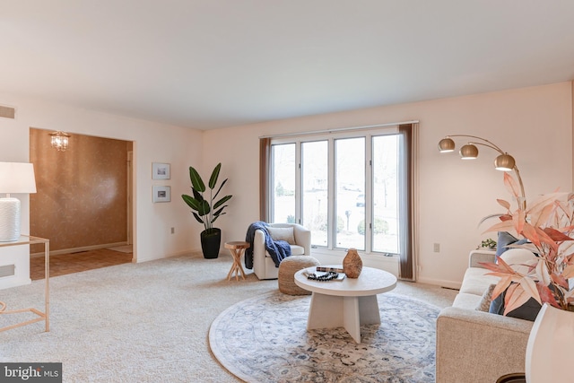 living area with visible vents, light carpet, and baseboards