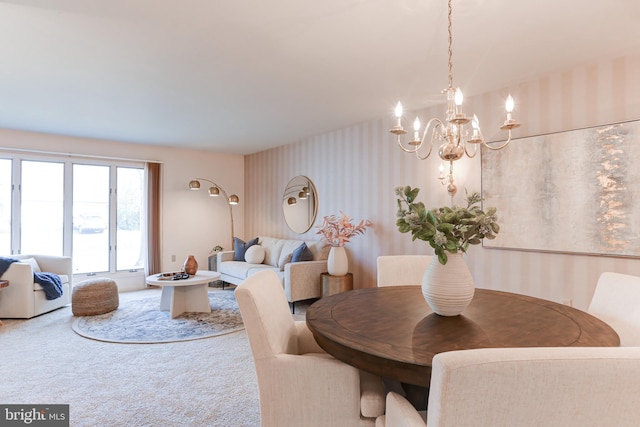 dining space featuring a chandelier, wallpapered walls, and carpet