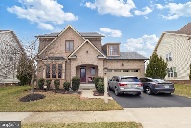 view of front of property with a front yard, a garage, brick siding, and driveway